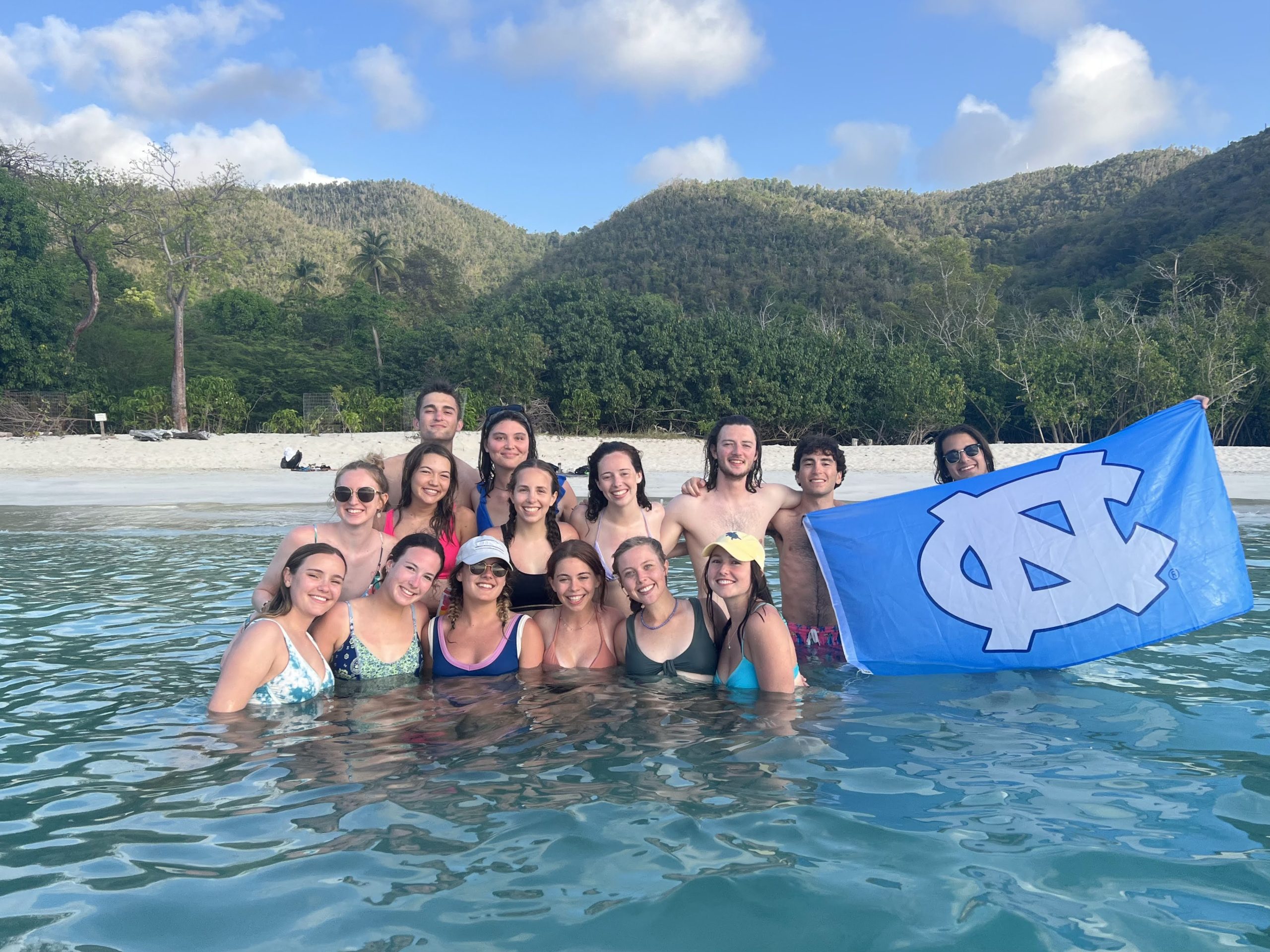 Student with UNC flag in the water in St. John.