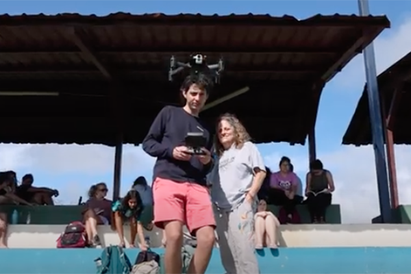 Two people holding drone remote control.