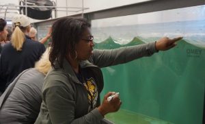 An energy literacy fellow points to a wave tank