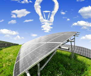 Solar panel in a grassy field with an electric bulb above it made from clouds.