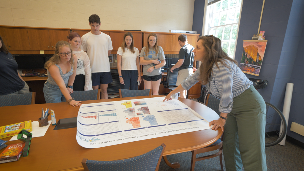 STFS students engage around a research poster.